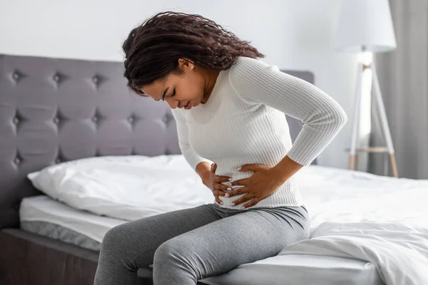 Femme enceinte ressentant des douleurs.
